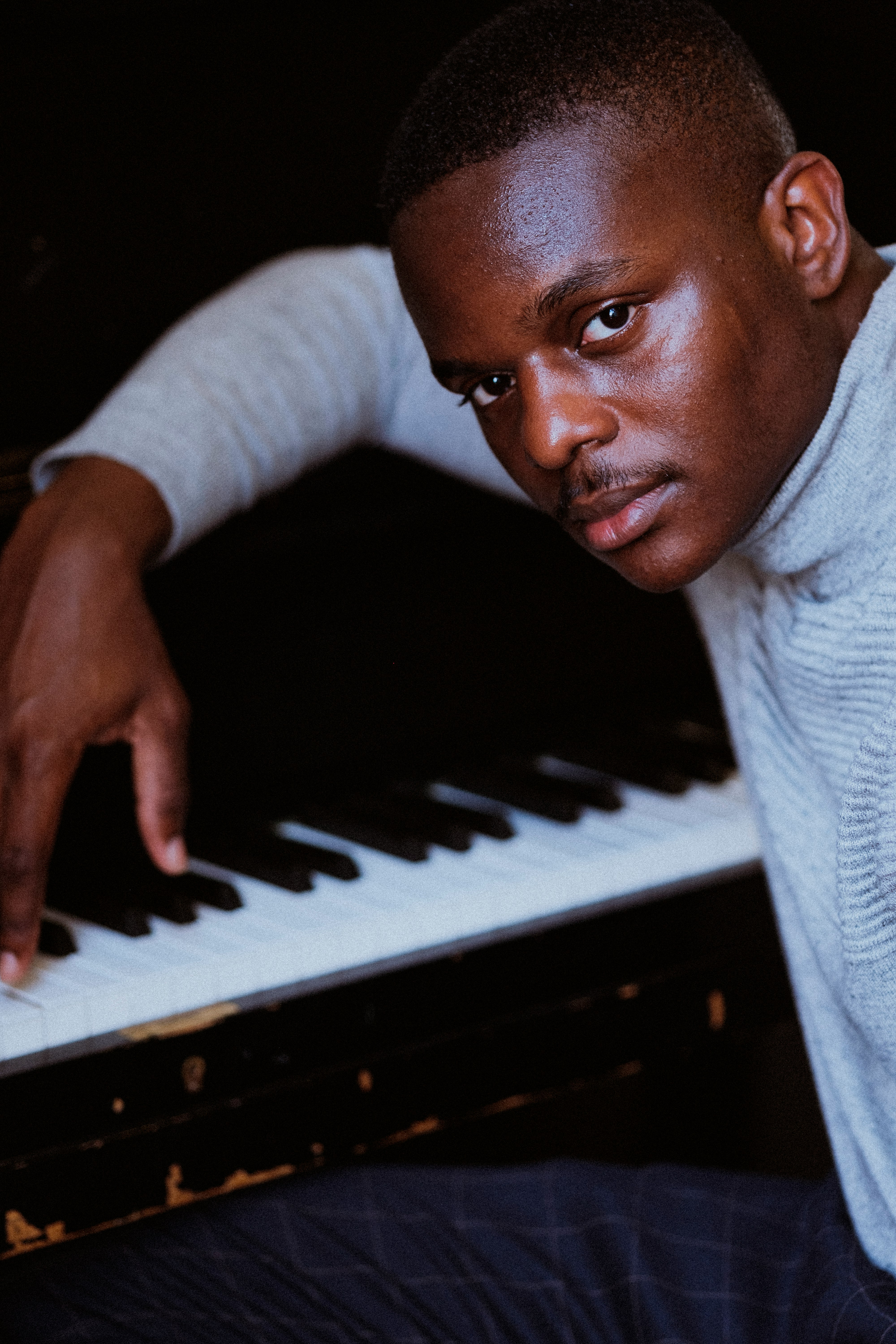 man in white long sleeve shirt playing piano